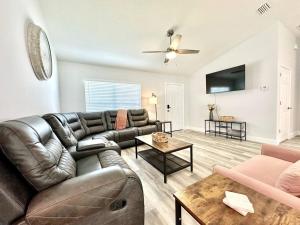 a living room with a leather couch and a table at White Oak Spacious and Comfy in Marion Oaks