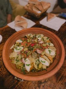 a bowl of food on a wooden table at Dania Surf House in Mirleft
