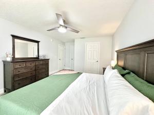 a bedroom with a bed and a dresser and a mirror at White Oak Spacious and Comfy in Marion Oaks