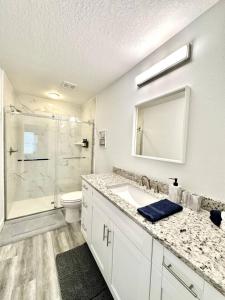 a white bathroom with a sink and a shower at White Oak Spacious and Comfy in Marion Oaks