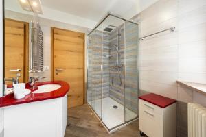 a bathroom with a red sink and a shower at Tobià de Barat in Pozza di Fassa +18 photos