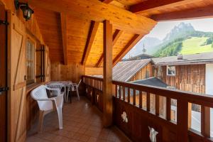 a balcony of a cabin with a table and chairs at Tobià de Barat in Pozza di Fassa