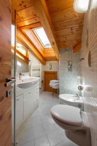 a bathroom with a toilet and a sink at Tobià de Barat in Pozza di Fassa