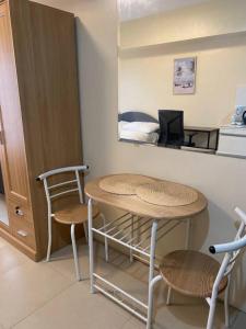 Habitación con mesa, sillas y escritorio. en Cozy Studio Unit Near IT Park with Pool Access, en Mabolo