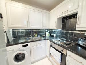 une cuisine blanche avec un évier et un lave-vaisselle dans l'établissement Central Renfrew 1BR Apt, à Renfrew 12 autres photos