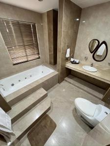 a bathroom with a tub and a toilet and a sink at Casa Vacacional Jpol in Cali