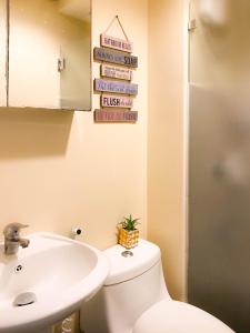 une salle de bain avec des toilettes blanches et un lavabo dans l'établissement Trendy Studio at Avida Riala It Park, à Mabolo