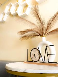 une table avec une horloge et un vase avec des plumes dans l'établissement Trendy Studio at Avida Riala It Park, à Mabolo