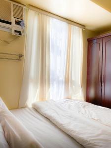 une chambre avec deux lits et une fenêtre dans l'établissement Trendy Studio at Avida Riala It Park, à Mabolo