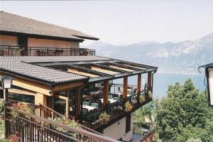 een huis met een balkon met uitzicht op het water bij Albergo Alle Fasse in Brenzone sul Garda