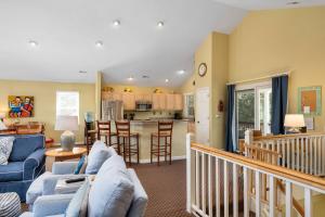 Una sala de estar con un sofá azul y una cocina. en Tee Dreams - C0432, en Sanderling