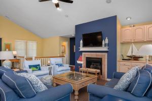 sala de estar con sillas azules y chimenea en Tee Dreams - C0432, en Sanderling
