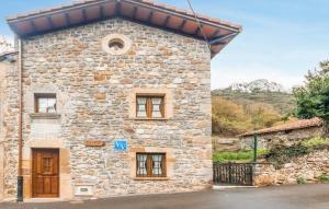a stone house with a roof on a street at Casa Enacantadora con Terraza y Barbacoa y vista Espectacular en TresCares Junto a Ruta de el Cares y Picos de Europa in Trescares