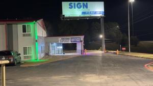 a sign in front of a gas station at night at Americas Best Value Inn Marshall in Bel Air