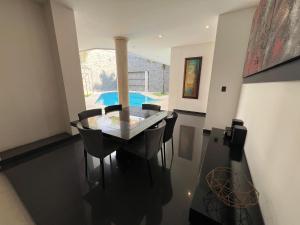 a dining room with a glass table and chairs at Casa Vacacional Jpol in Cali