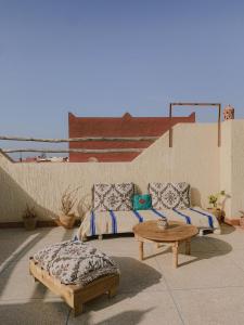 a patio with a couch and a coffee table at Dania Surf House in Mirleft