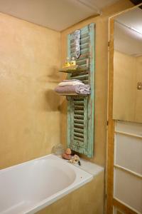 罗亚河畔布雷伊studio calme et lumineux的浴室里有浴缸、一些毛巾和一面镜子。