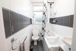 une salle de bains blanche avec toilettes et lavabo dans l'établissement Stylish 2BR in Renfrew, à Renfrew