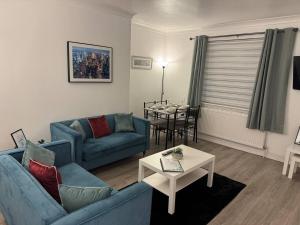 un salon avec deux canapés bleus et une table dans l'établissement Stylish 2BR in Renfrew, à Renfrew