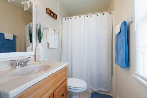 a bathroom with a sink and a toilet and a mirror at SURFRIDER Dewey Beach Ocean Block in Dewey Beach +42 photos