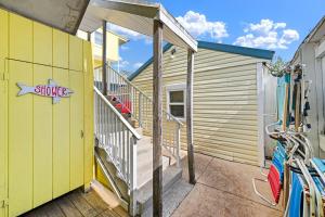 a yellow house with a stairs next to a garage at SURFRIDER Dewey Beach Ocean Block in Dewey Beach