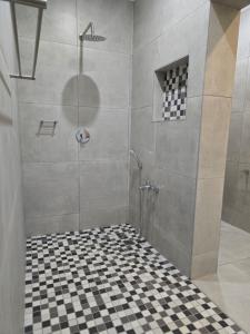 Apartment 33 في خليج ريتشاردز: دش مع أرضية ملونة سوداء وبيضاء
