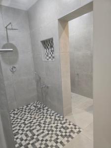 Apartment 33 في خليج ريتشاردز: دش مع أرضية ملونة سوداء وبيضاء