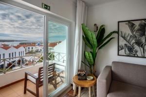 a living room with a couch and a balcony at Villa Eira in Vila Nova de Milfontes