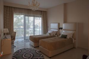 a hotel room with two beds and a chandelier at Beachfront Home with Sea View - 2BR, 134m2 in Lusail