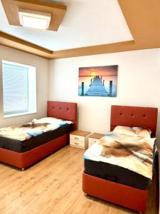 a bedroom with two beds and a painting on the wall at kERVANHOF an der Donau in Kleinpöchlarn
