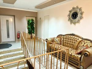 a living room with a couch and a clock on the wall at kERVANHOF an der Donau in Kleinpöchlarn +21 photos