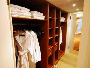 un placard rempli d'étagères en bois et de serviettes. dans l'établissement Gartensuite-Kamin-Sauna-Pool-Garten, à Kampen
