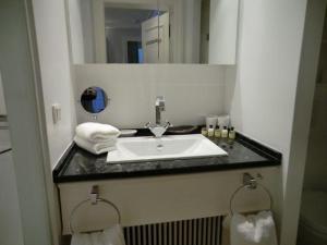 une salle de bain avec un lavabo, un miroir et des serviettes dans l'établissement Gartensuite-Kamin-Sauna-Pool-Garten, à Kampen 9 autres photos