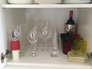 un paquet de verres à vin assis sur une étagère dans l'établissement Gartensuite-Kamin-Sauna-Pool-Garten, à Kampen