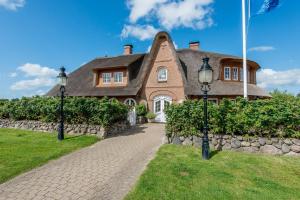 une grande maison en briques avec un drapeau devant elle dans l'établissement Gartensuite-Kamin-Sauna-Pool-Garten, à Kampen
