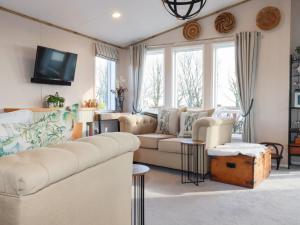 a living room with a couch and a tv at Fairways 4 in Liskeard
