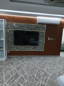 un salon avec une cheminée et une télévision dans l'établissement Mountain Park Rest, à Ḑab‘ah