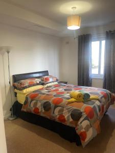 une chambre avec un lit avec une couette colorée dans l'établissement Executive 1 Bed Lovely Apartment, à Aberdeen