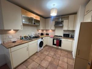 une cuisine avec des armoires blanches et une machine à laver dans l'établissement Executive 1 Bed Lovely Apartment, à Aberdeen