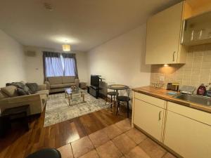 a kitchen and living room with a couch and a table at Executive 1 Bed Lovely Apartment in Aberdeen