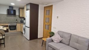 a living room with a couch and a kitchen at Lo Pateret in Corbera