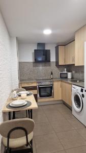 una cucina con tavolo e lavatrice di Lo Pateret a Corbera Altre 13 foto