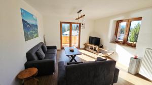 a living room with two couches and a tv at Chalet Weitsee in Reit im Winkl