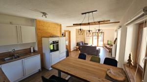 a kitchen and living room with a wooden table and a dining room at Chalet Weitsee in Reit im Winkl