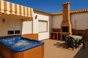 ein Whirlpool auf einer Terrasse mit einem Tisch und einem Esszimmer in der Unterkunft Casas en el palmar in El Palmar