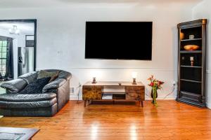 ein Wohnzimmer mit einem Sofa und einem Fernseher an der Wand in der Unterkunft 6 Mi to Marietta Square Family Retreat with Yard! in Macland