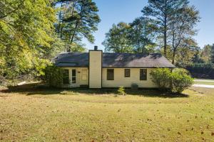 ein kleines weißes Haus inmitten eines Gartens in der Unterkunft 6 Mi to Marietta Square Family Retreat with Yard! in Macland