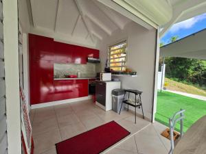 a kitchen with red cabinets and a red wall at Location bungalow in Le Gosier