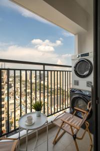 ein Balkon mit Tisch und Blick auf eine Stadt in der Unterkunft Soho Residence & Apartments by Serenity Living - City Center District 1 - Premium Studios & 2-3 Bedrooms Suite, Next Bui Vien in Ho-Chi-Minh-Stadt