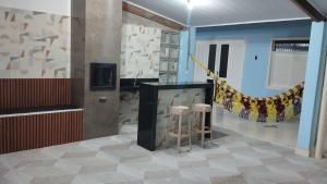 a room with a counter with stools and a tv at Aquarela do Sertão in Piranhas